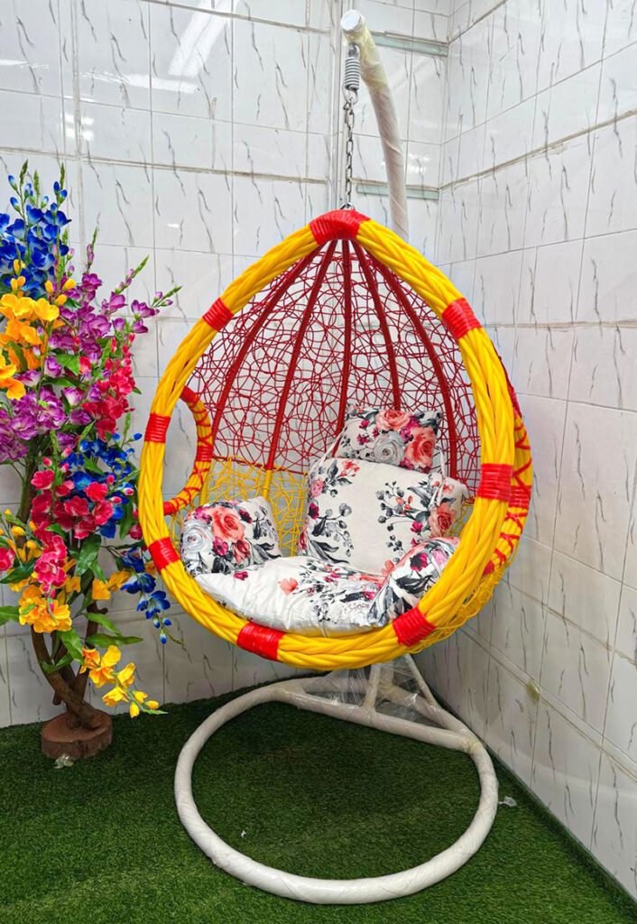 "Premium hanging egg swing chair with stand, yellow and red PE rattan design, white floral cushions, heavy-duty steel frame, 180 kg capacity, perfect for balcony, garden, patio, and living room."