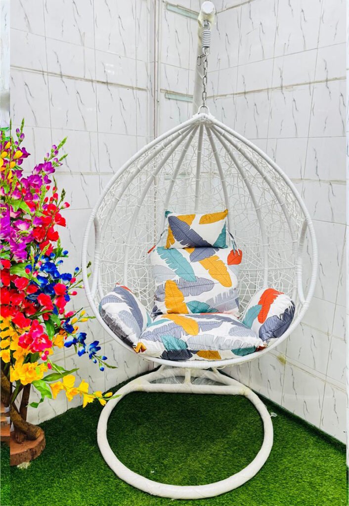 Premium white hanging egg swing chair with heavy-duty metal stand, colorful leaf-pattern cushions, PE rattan basket, 180 kg weight capacity, ideal for indoor and outdoor use.